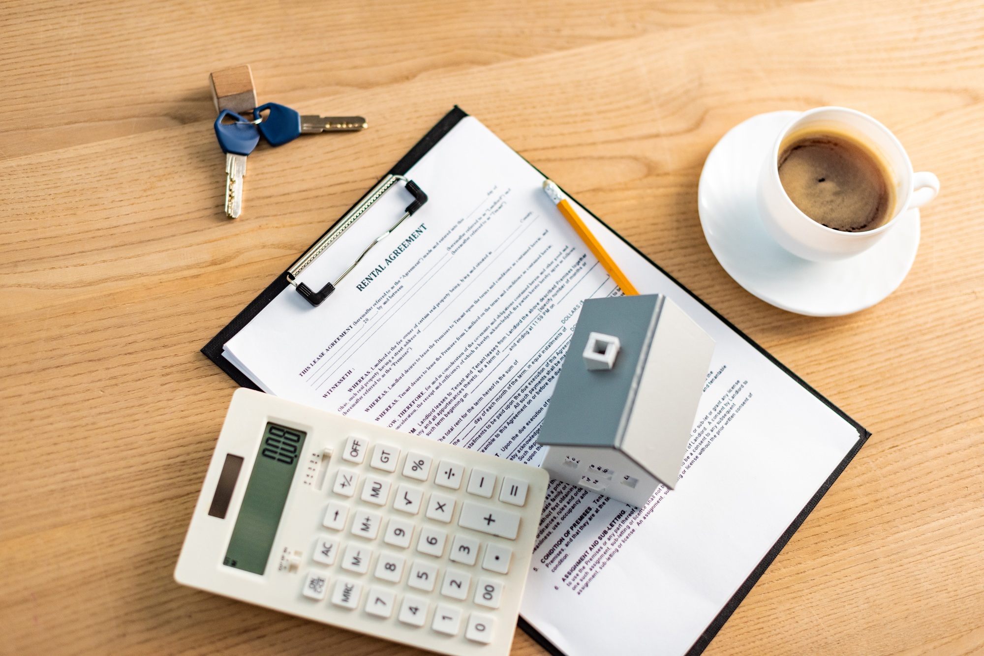 top view of cup of coffee near clipboard with rental agreement lettering on table